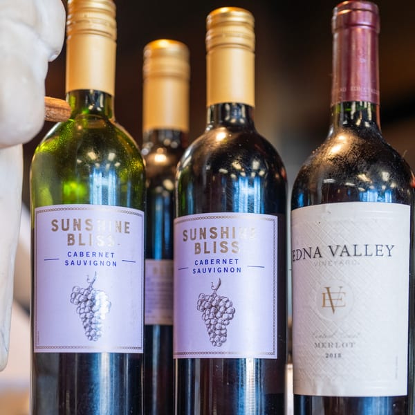 Four bottles of red wine, two "Sunshine Bliss Cabernet Sauvignon" and one "Edna Valley Merlot".