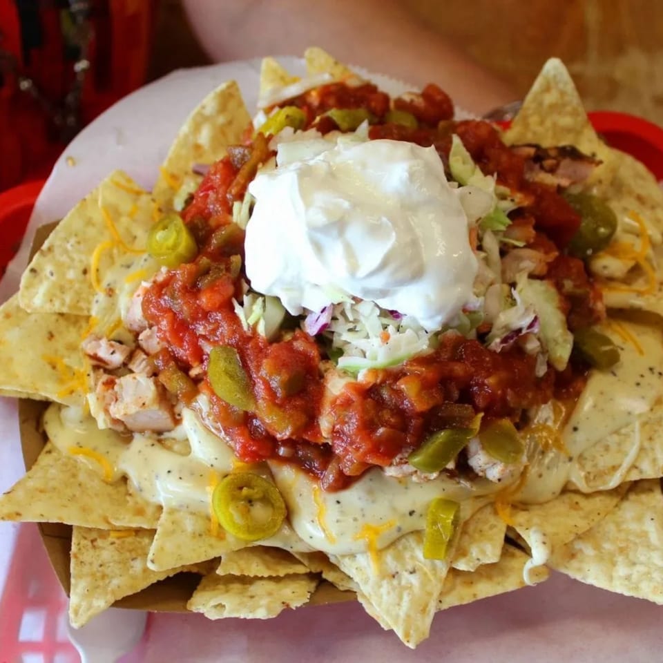 Buster's Southern Pit BBQ nachos with chicken, cheese sauce, salsa, jalapeños, and sour cream.